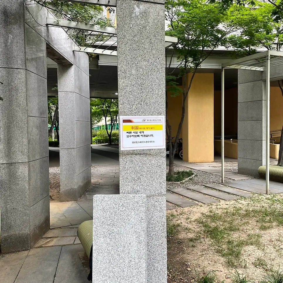 위험 안내문이 부착된 아파트 단지 파고라 기둥 시공 전